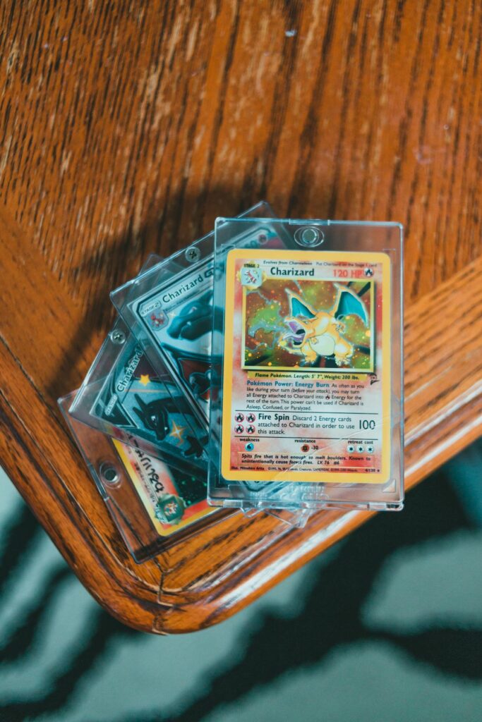 A Charizard card in a clear top-loader on an oak table